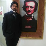 Rubén Gracia, caracterizado de Poe, junto al retrato hecho por los chicos del Taller de artesanía